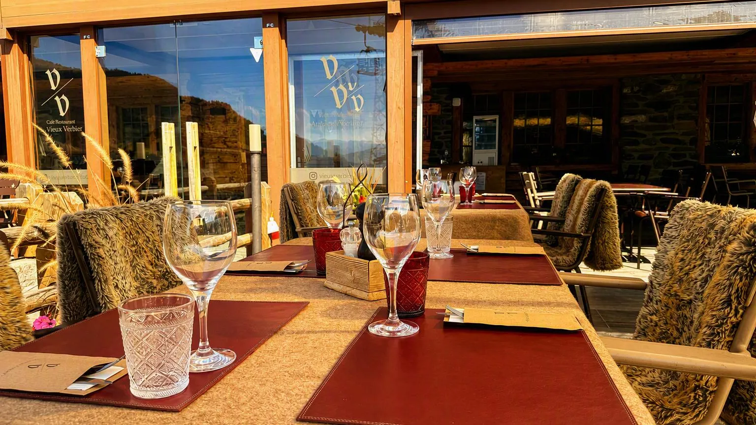La terrasse couverte au soleil couchant, le monogramme gravé sur la vitre