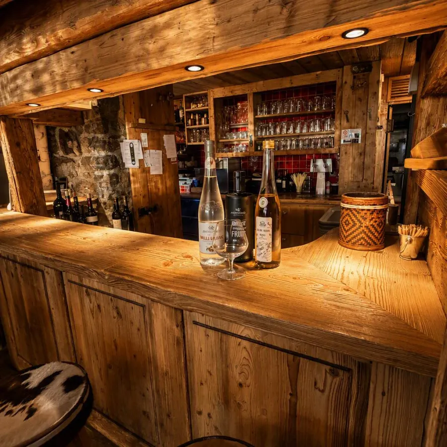 Le bar en vieux bois et ses tabourets en peau