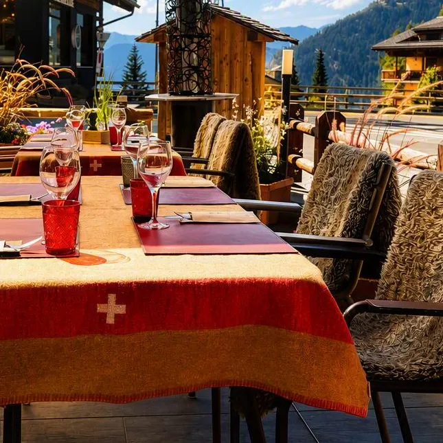 La terrasse en été, nappe à croix suisse face à la vallée