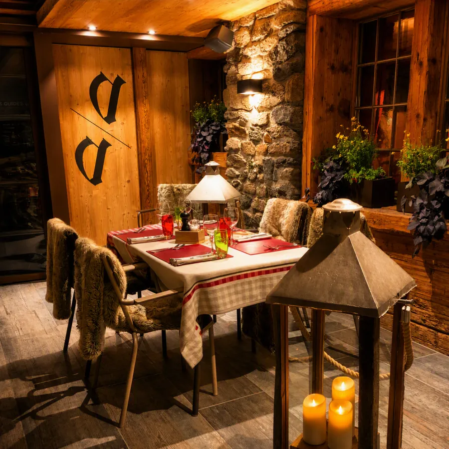 La terrasse à la nuit tombée, le monogramme peint sur le bois et les lanternes allumées